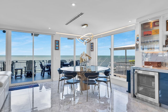 257 Normandy Dr, Tavernier, FL 33070 - dining space featuring wine cooler, plenty of natural light, a bar, a wall of windows, and a water view