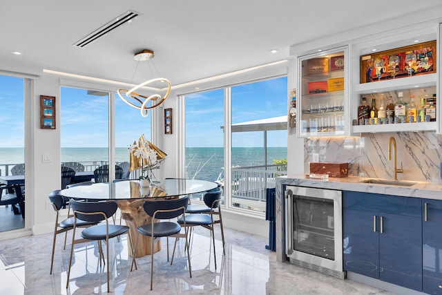 257 Normandy Dr, Tavernier, FL 33070 - dining room featuring wine cooler, healthy amount of natural light, bar area, a water view, and a wall of windows