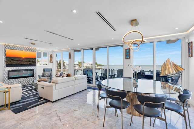 257 Normandy Dr, Tavernier, FL 33070 - dining space featuring a glass covered fireplace, marble tiled floors, a wall of windows, a water view, and recessed lighting