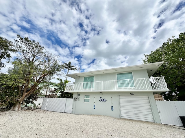 rear view of property featuring a garage and a balcony