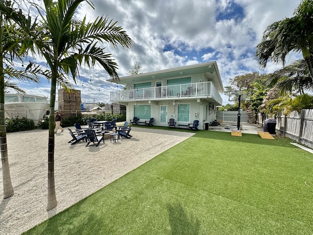 back of house featuring a balcony, a yard, and a patio