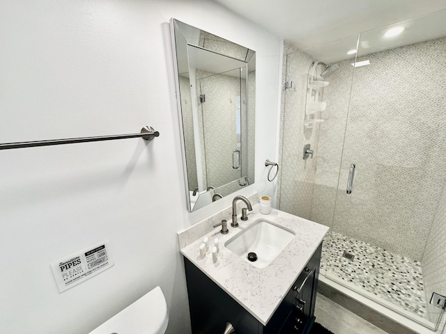 bathroom featuring vanity, an enclosed shower, and toilet