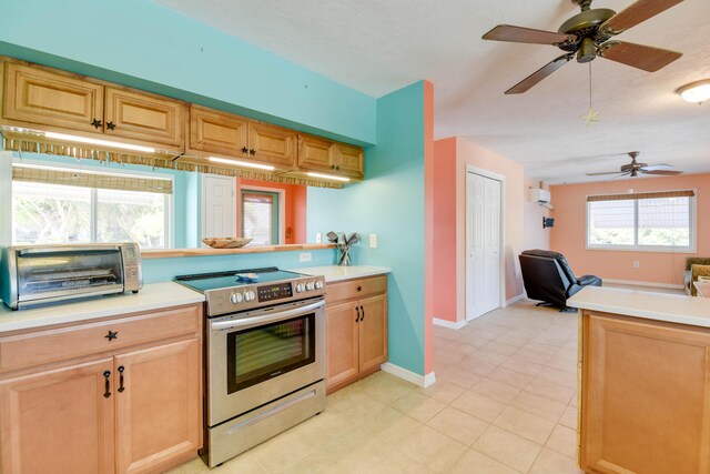 kitchen with an AC wall unit, kitchen peninsula, and stainless steel electric range oven