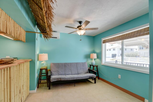 sitting room with ceiling fan and a wall mounted AC