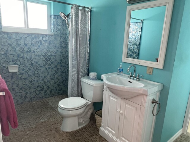 bathroom featuring tile patterned flooring, vanity, curtained shower, and toilet