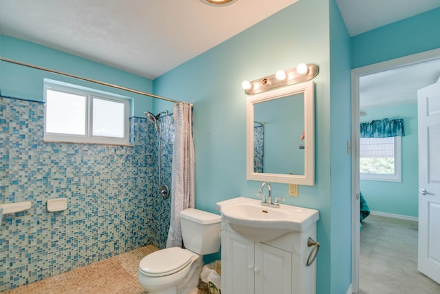 bathroom featuring vanity, a healthy amount of sunlight, curtained shower, and toilet