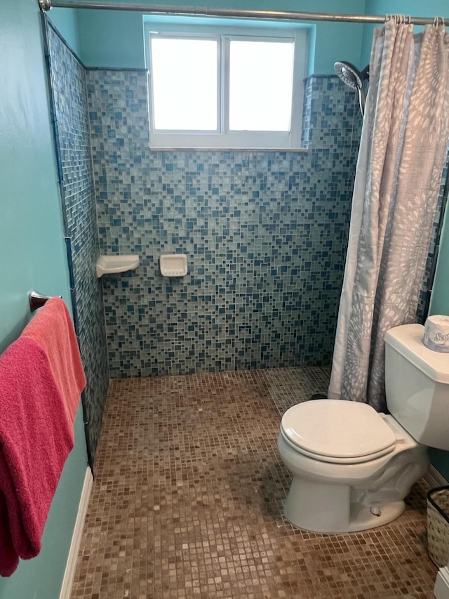 bathroom with tile patterned flooring, a shower with shower curtain, and toilet