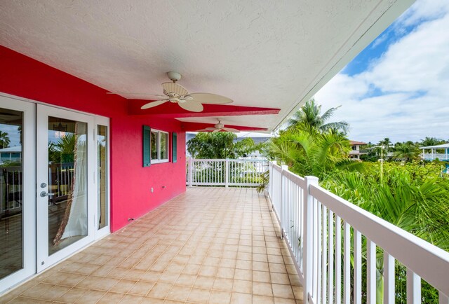 view of patio featuring french doors, ceiling fan, and a balcony