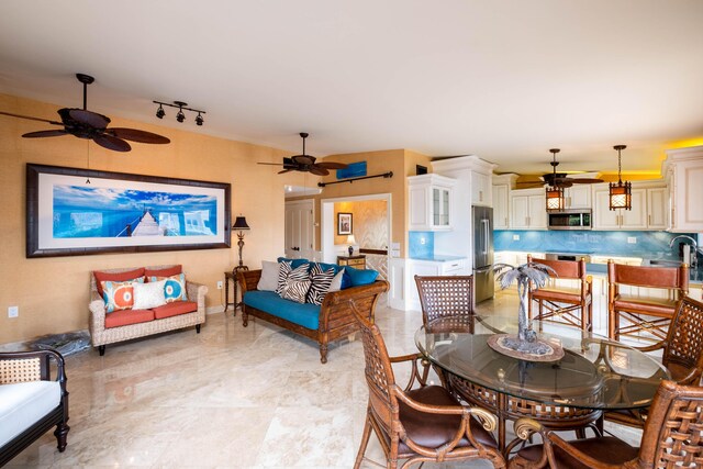 dining room with ceiling fan and sink