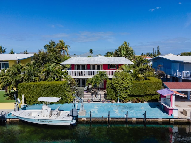 back of property with a balcony and a water view