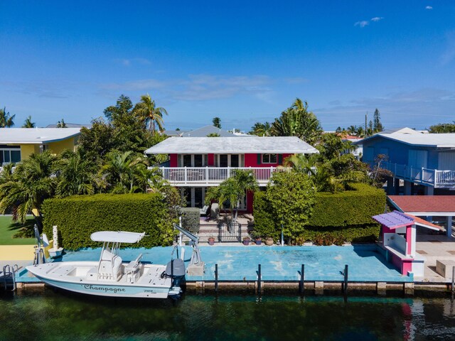 back of house with a patio, a water view, and a balcony