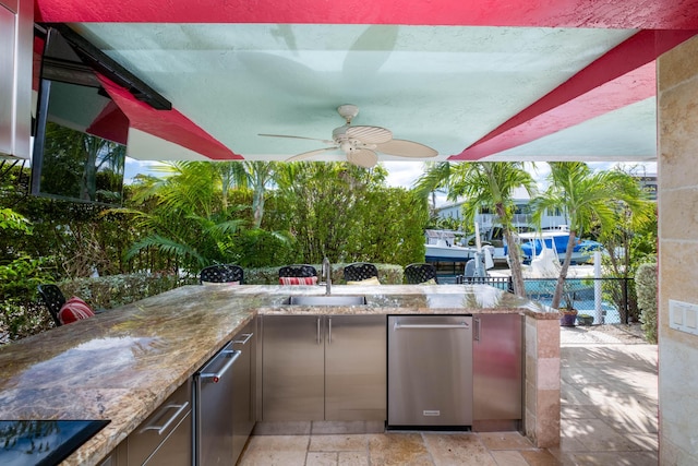 view of patio / terrace with area for grilling, ceiling fan, a sink, fence, and outdoor wet bar