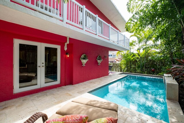 view of swimming pool with french doors and a patio