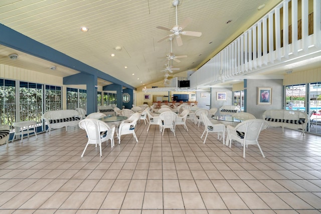 tiled dining area featuring ceiling fan and high vaulted ceiling