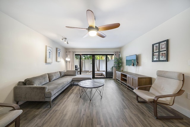 living room featuring dark wood-type flooring and ceiling fan