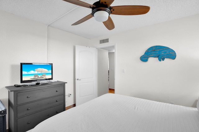 bedroom featuring ceiling fan and a textured ceiling