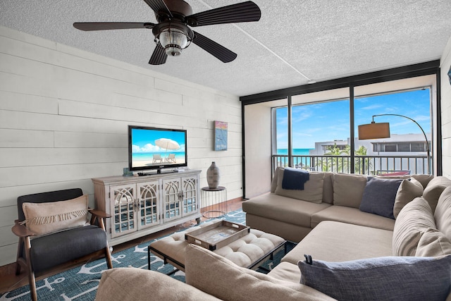 living room with ceiling fan, hardwood / wood-style floors, and a textured ceiling