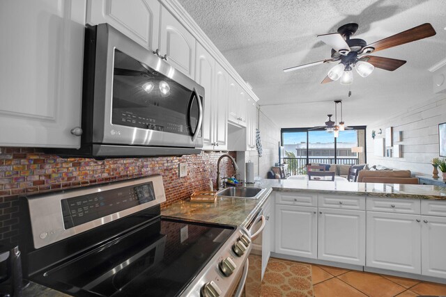 kitchen featuring white cabinetry, appliances with stainless steel finishes, sink, and light tile patterned floors