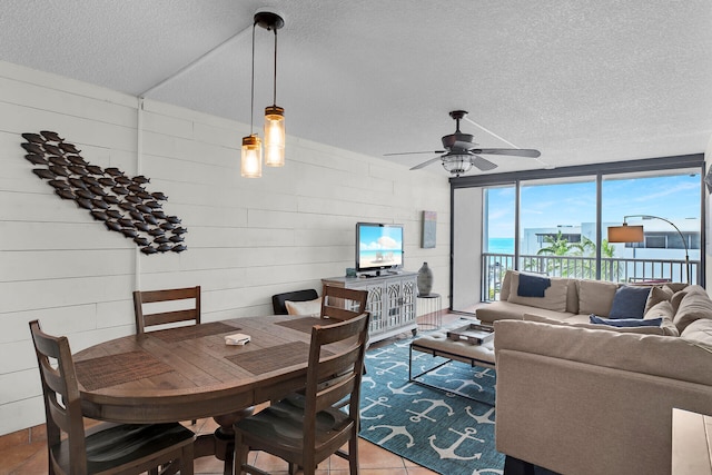 tiled dining area featuring ceiling fan and a textured ceiling