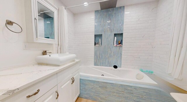 bathroom with tiled shower / bath and vanity