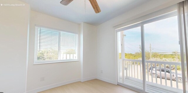 spare room with ceiling fan and light wood-type flooring