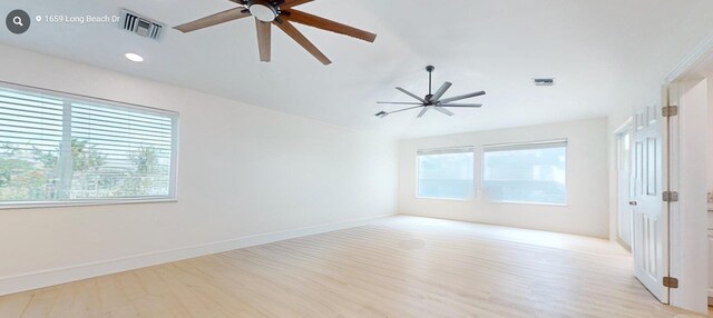 empty room with lofted ceiling, ceiling fan, and light hardwood / wood-style flooring