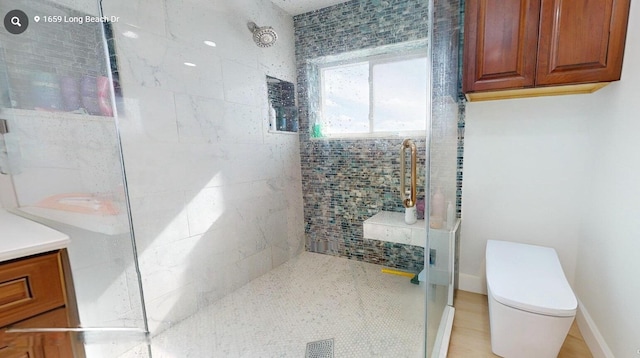 bathroom with vanity, toilet, and a shower with shower door