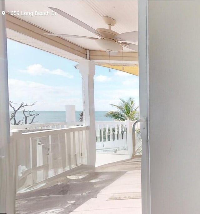 doorway featuring ceiling fan and a water view