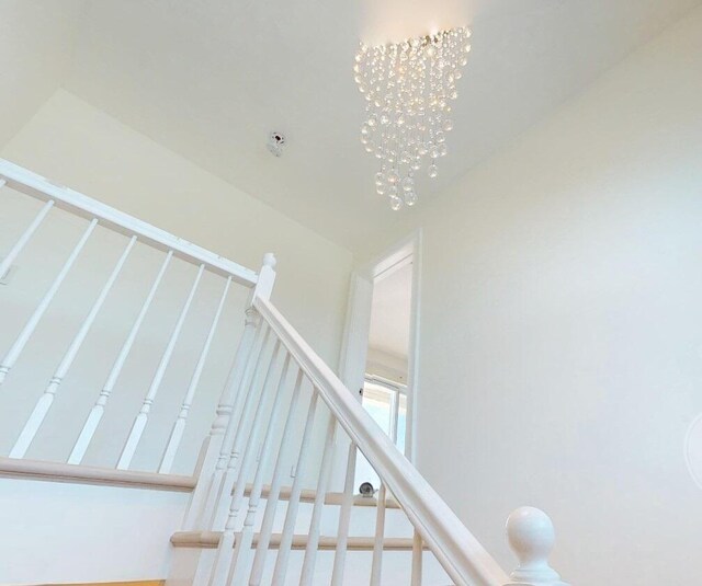 stairway featuring an inviting chandelier