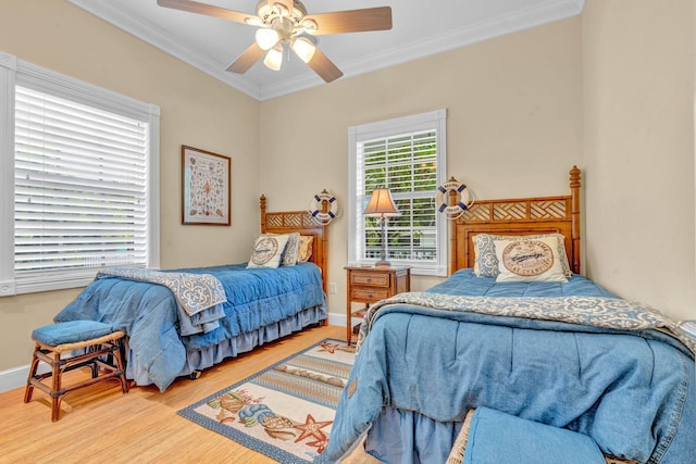 bedroom with crown molding, ceiling fan, and hardwood / wood-style floors