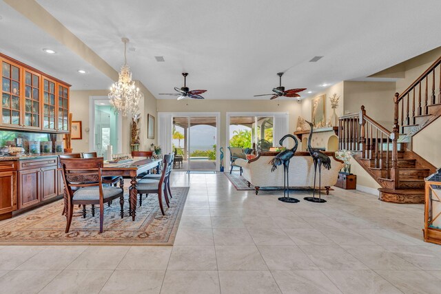 tiled dining room featuring ceiling fan with notable chandelier