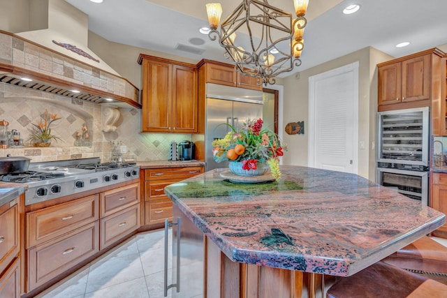 kitchen with appliances with stainless steel finishes, a center island, a kitchen bar, and custom range hood