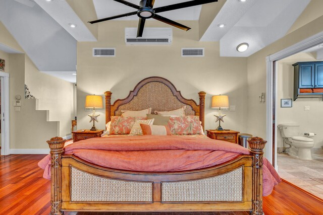 bedroom with hardwood / wood-style flooring and ensuite bath