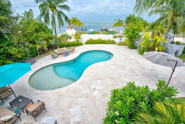 view of swimming pool featuring a water view and a patio area