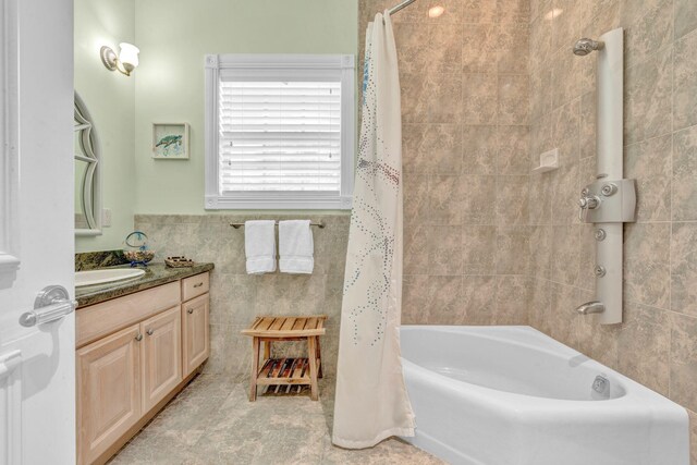 bathroom with vanity, tile walls, and shower / tub combo