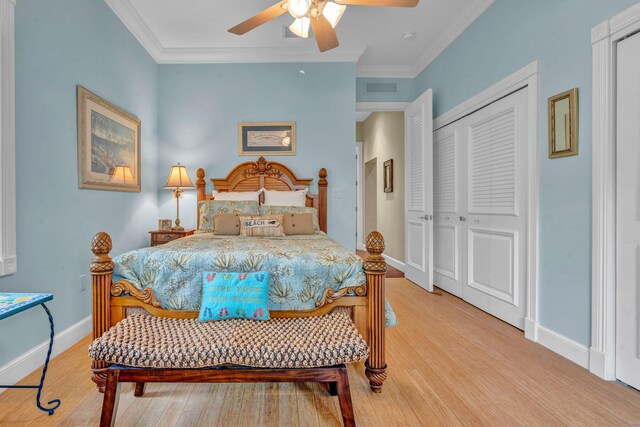 bedroom featuring ornamental molding, a closet, ceiling fan, and light hardwood / wood-style flooring