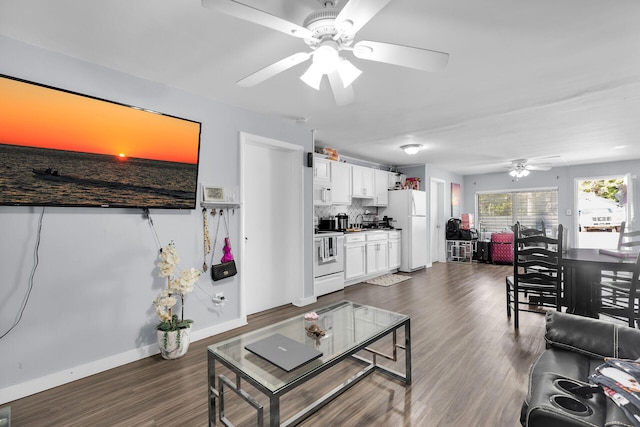 living area featuring dark wood-type flooring, a ceiling fan, and baseboards