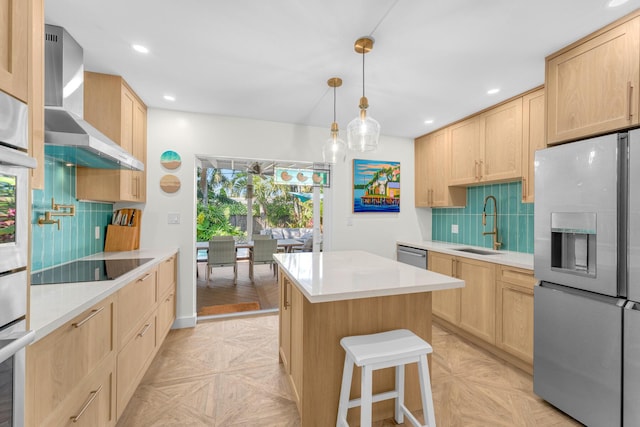 kitchen featuring appliances with stainless steel finishes, sink, light brown cabinets, light parquet floors, and wall chimney range hood