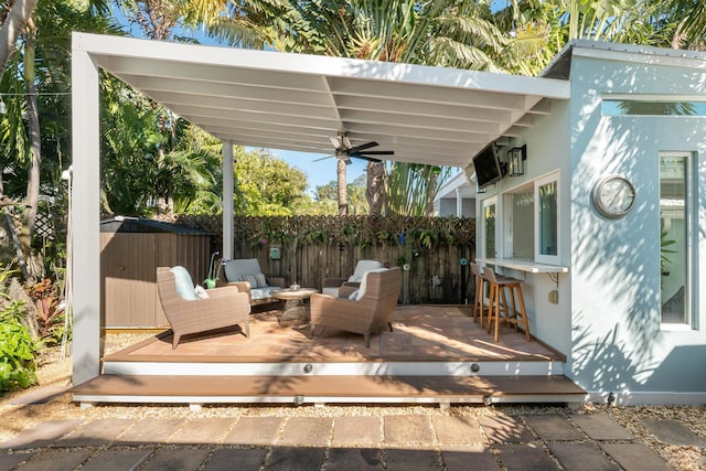 view of patio / terrace featuring an outdoor hangout area, ceiling fan, exterior bar, and a deck