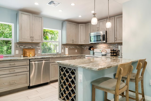 217 Gasparilla Dr, Key Largo, FL 33037 - kitchen featuring stainless steel appliances, backsplash, recessed lighting, a kitchen breakfast bar, and a peninsula
