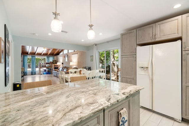 217 Gasparilla Dr, Key Largo, FL 33037 - kitchen featuring white fridge with ice dispenser, light stone counters, recessed lighting, decorative light fixtures, and light tile patterned floors