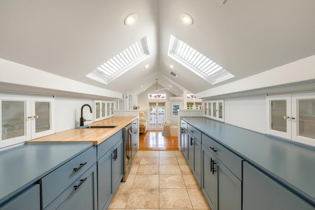 525 Simonton St, Key West, FL 33040 - kitchen featuring french doors, a skylight, lofted ceiling, glass insert cabinets, and wooden counters