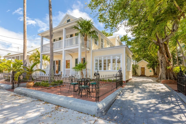 525 Simonton St, Key West, FL 33040 - neoclassical home with a balcony, a fenced front yard, and concrete driveway