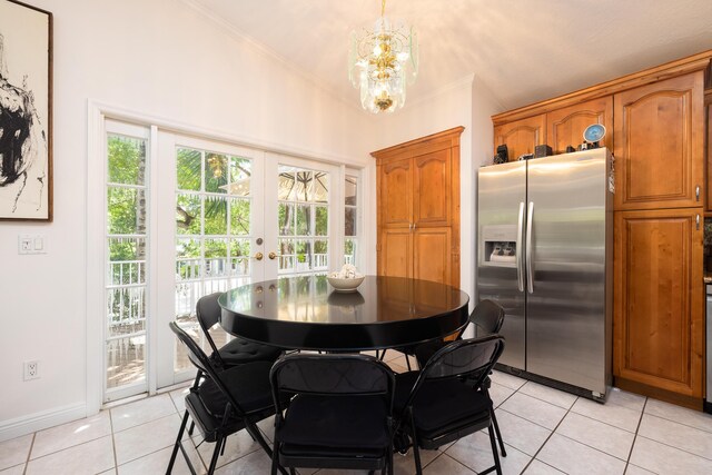 dining space featuring an inviting chandelier, light tile patterned floors, ornamental molding, and french doors