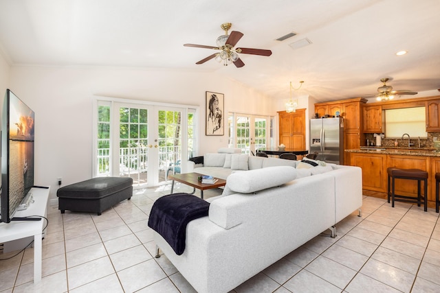 living room featuring lofted ceiling, light tile patterned floors, ceiling fan, and french doors