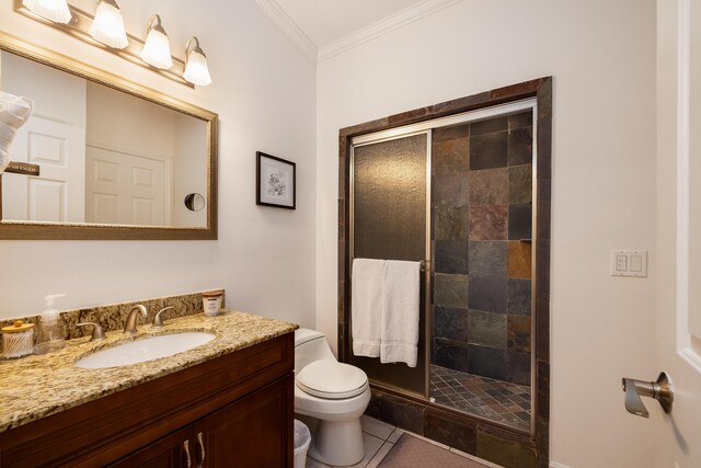 bathroom featuring tile patterned floors, toilet, ornamental molding, vanity, and a shower with door