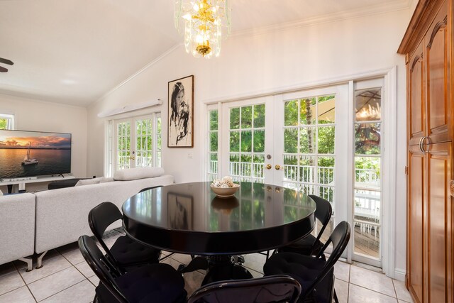 dining area featuring crown molding, vaulted ceiling, a notable chandelier, and french doors