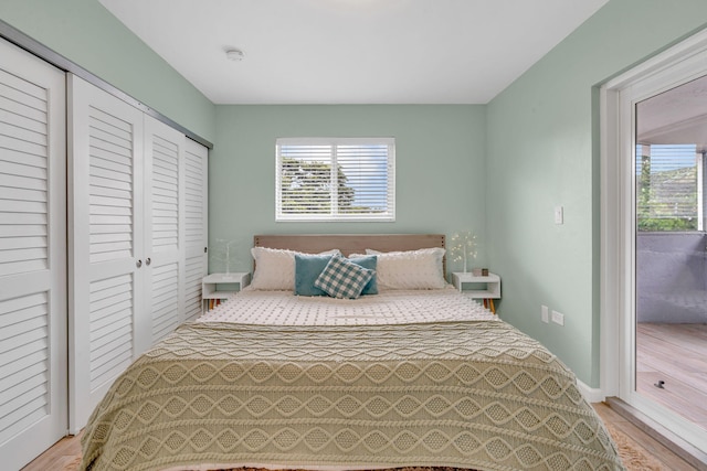 bedroom featuring access to exterior and light wood-type flooring