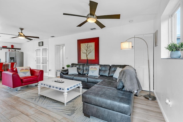 living room with ceiling fan and light hardwood / wood-style floors