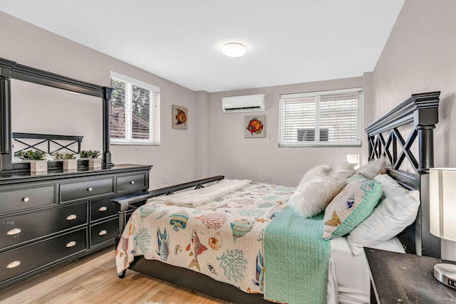 bedroom featuring light wood-type flooring and an AC wall unit